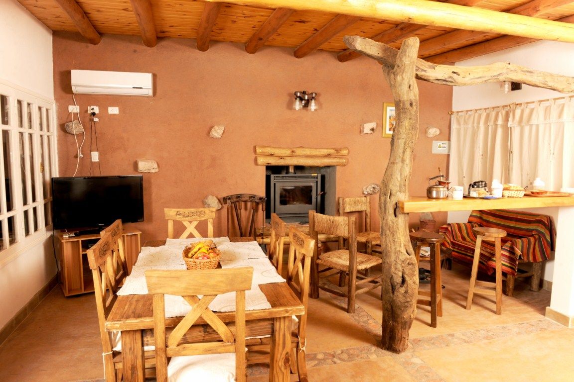 Interior de la Cabaña de Campo con comedor, barra, hogar y televisión