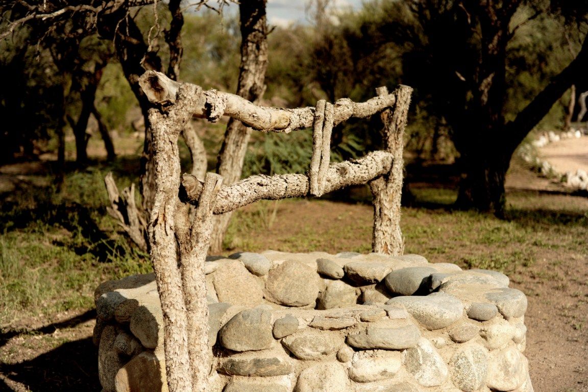 Pozo rústico de piedra y madera en el entorno del predio