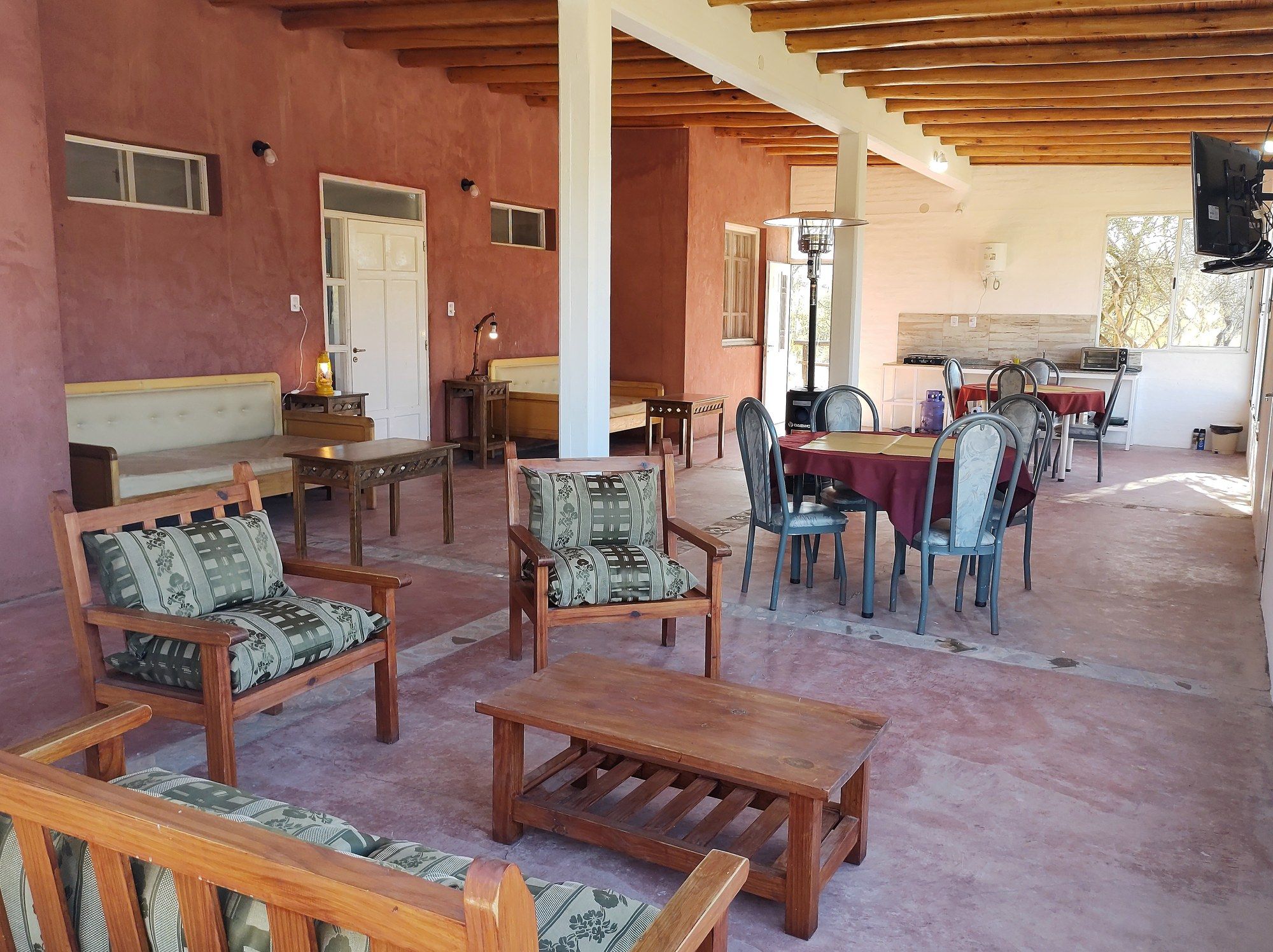 Espacio común destinado a huéspedes de los Monoambientes, con mesas, sillones y sector de cocina